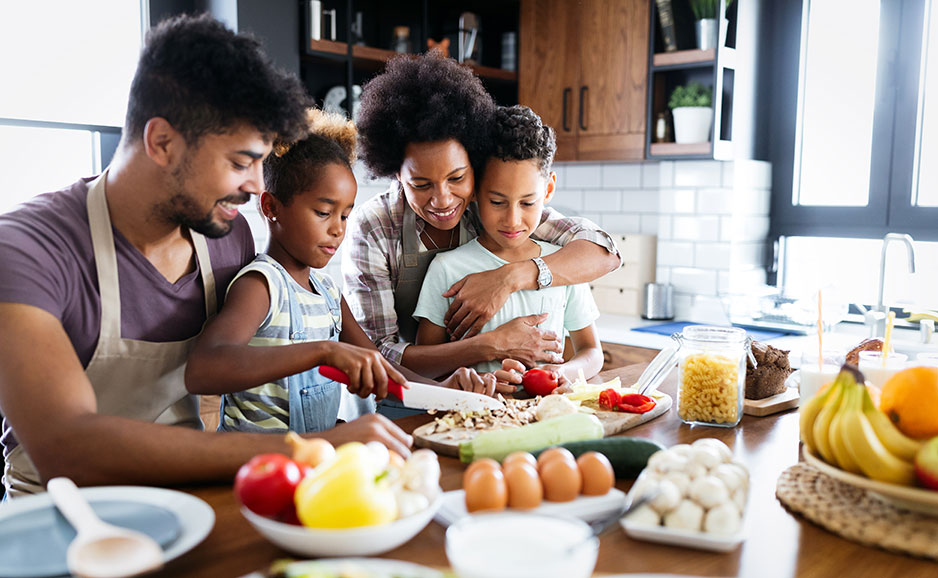 Happy family in the kitchen having fun and cooking healthy food together at home.