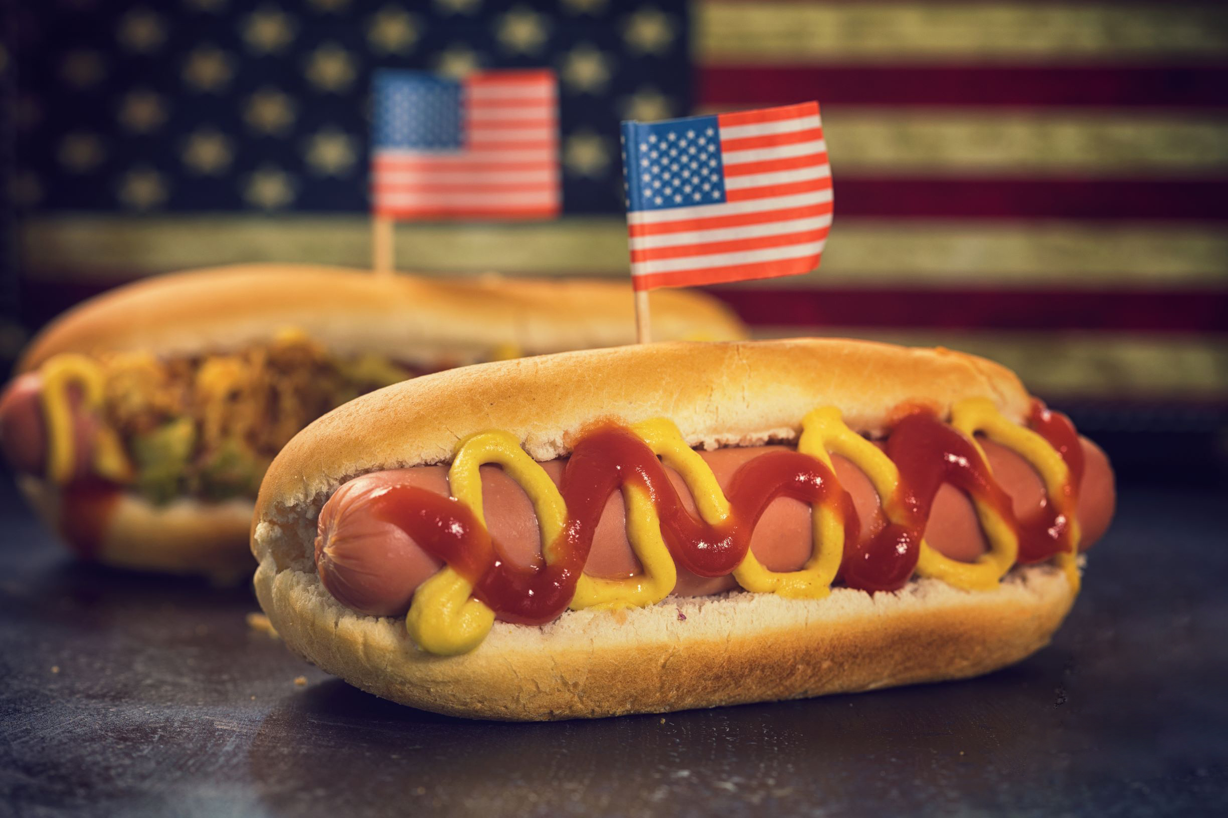 A hot dog in a bun with mustard and ketchup.