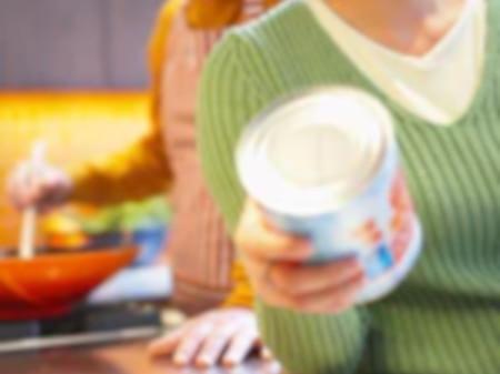 Mujer inspeccionando un alimento envasado en la cocina