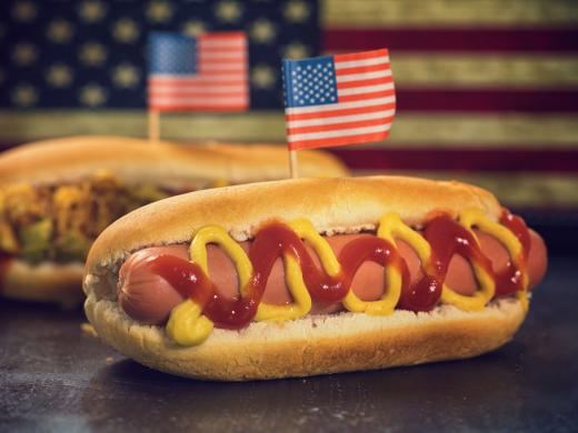 A hot dog in a bun with mustard and ketchup.