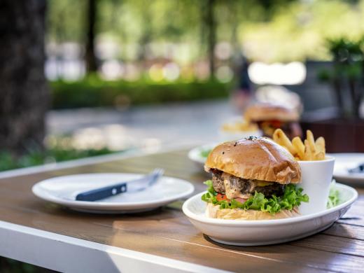 Una hamburguesa y papas fritas en una mesa de restaurante al aire libre.