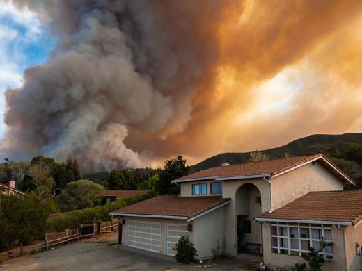 Wildfire smoke behind a home.