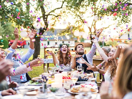 Wedding party celebrates al fresco at a summer garden reception.