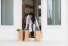 A women picks up groceries delivered on her doorstep.